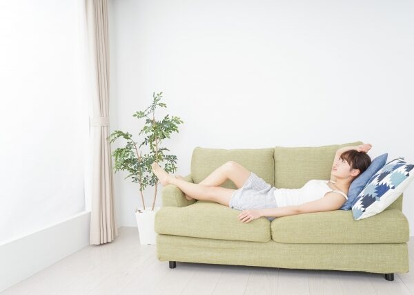 リラックスする女性がソファに横になって休息している