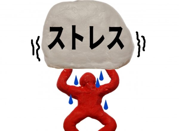 赤い人形が頭上で大きな「ストレス」と書かれた白い岩を支えている彫刻。人形からは汗が滴り、ストレスの重圧を表現している。